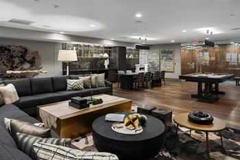 A living room with couches and tables and a pool table